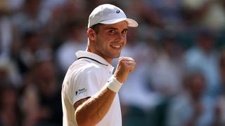 Arthur Fery, wearing a baseball cap, punches the air after winning a point at Wimbledon 2026