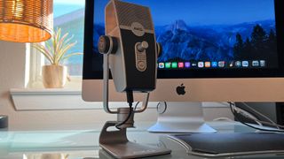 An AKG Lyra on a desk in front of an iMac
