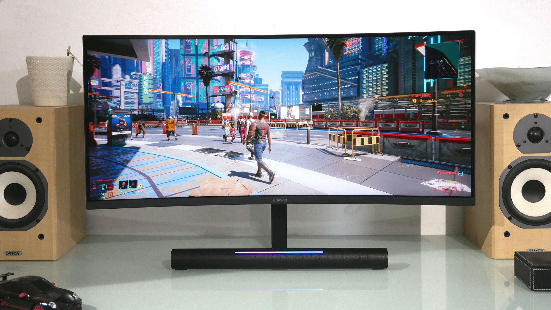 Huawei MateView GT on a glass desk fringed by two speakers