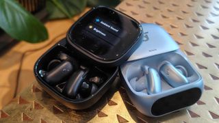 The Anker Soundcore Liberty 5 Pro and Anker Soundcore Liberty 5 Pro Max on a bronze table.