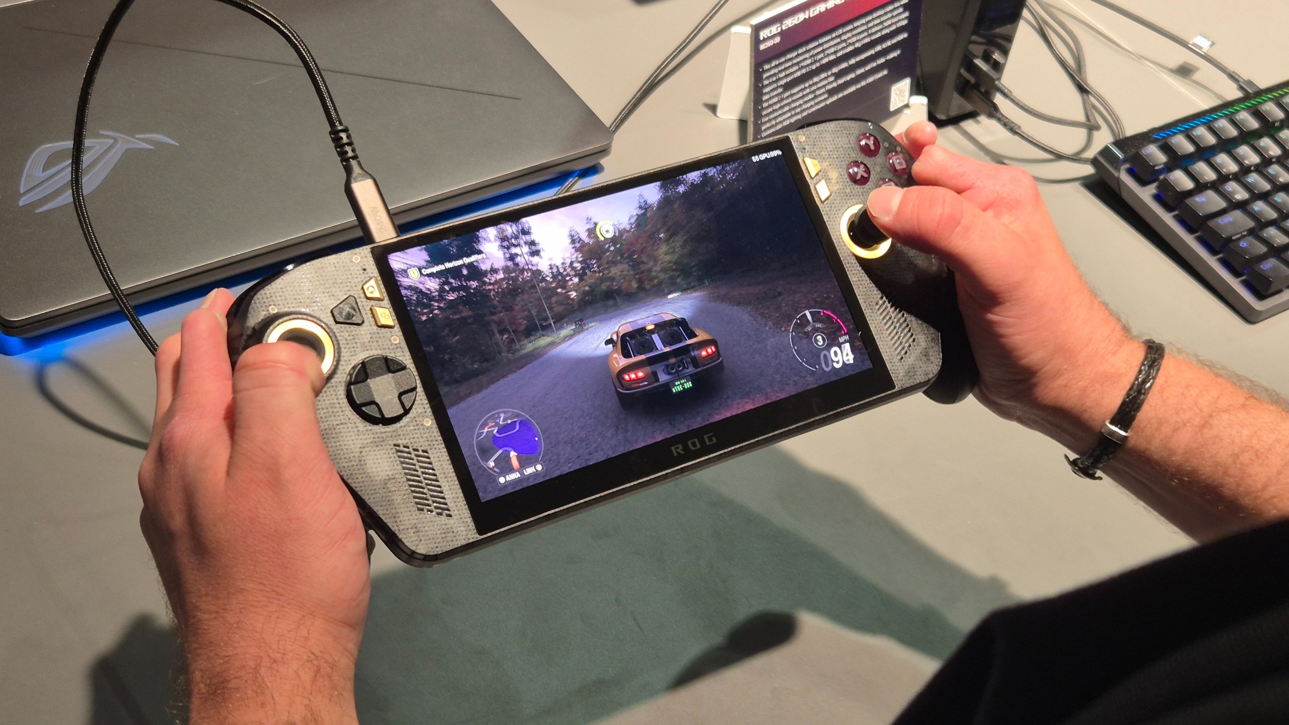 The Asus ROG Xbox Ally X20 handheld being held in the hands of a man, playing Forza Horizon 5