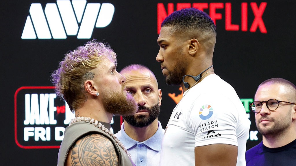 Jake Paul and Anthony Joshua square up to each other at a press conference before their heavyweight boxing fight in Miami, Florida.