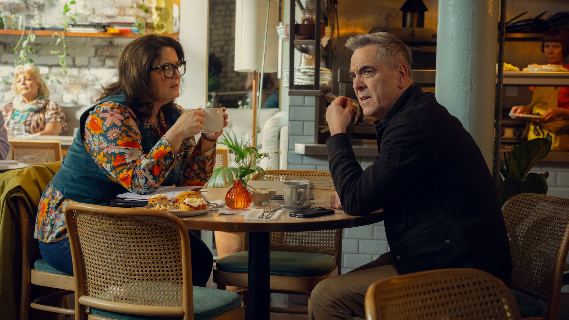 Elena and Simon sit at a cafe table