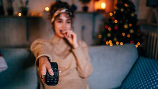 Woman watching movies at home with a Christmas tree in the background