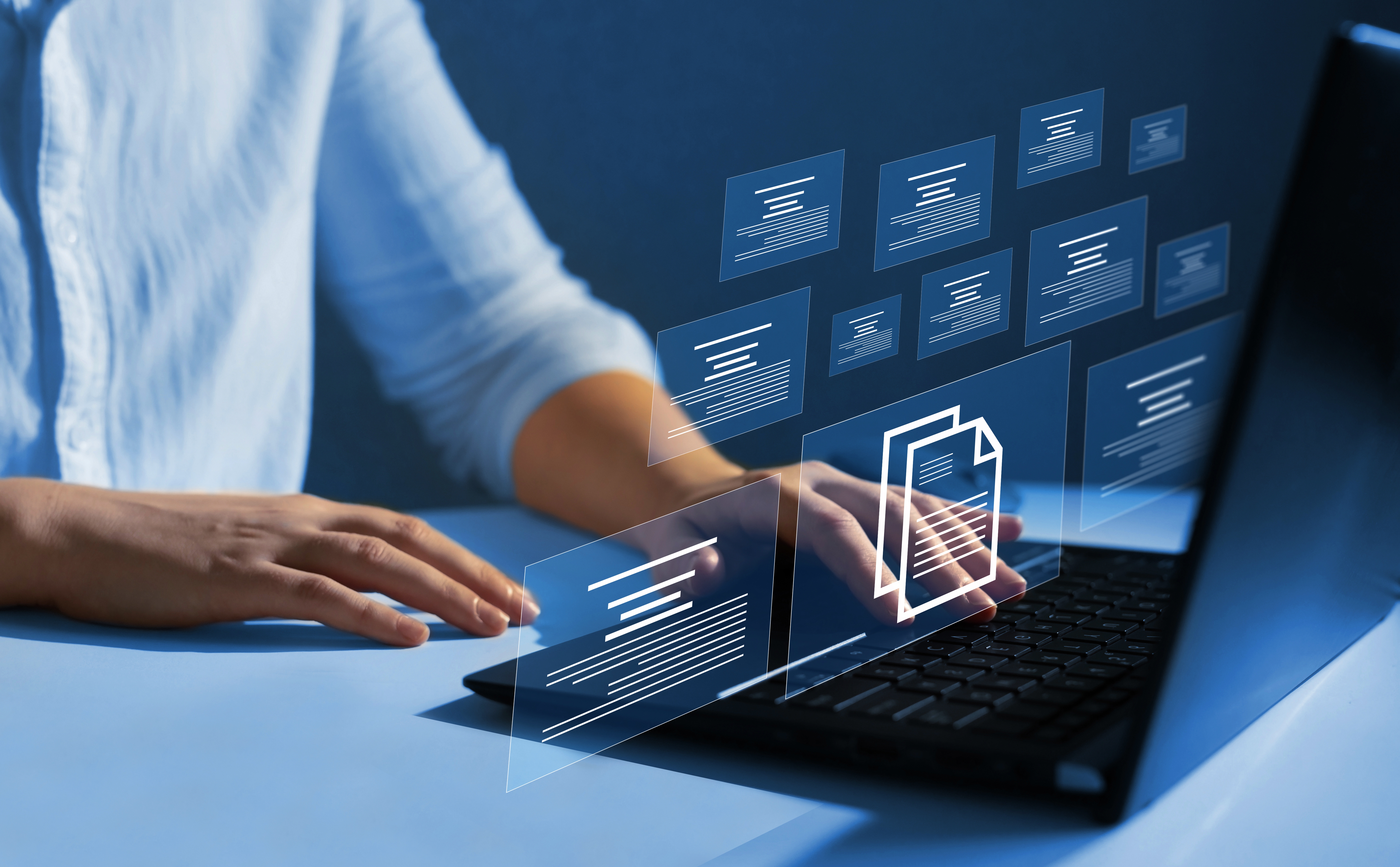 A person using a laptop with multiple floating icons emerging from the screen.
