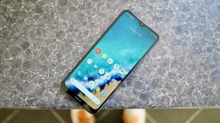 A photo of the Nokia G50 lying on a surface, with the home screen visible