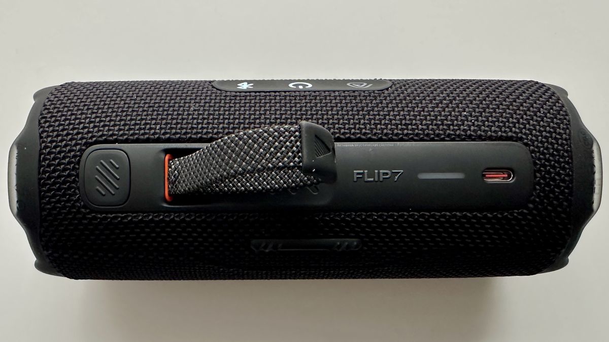 Carry strap of the JBL Flip 7 portable Bluetooth speaker, on a white surface