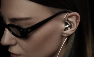 Meze Audio Astru worn by a woman wearing glasses, in profile