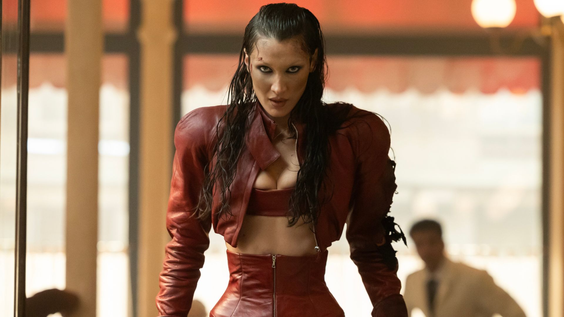 Bella Hadid stands looking forward with a cut on her face 