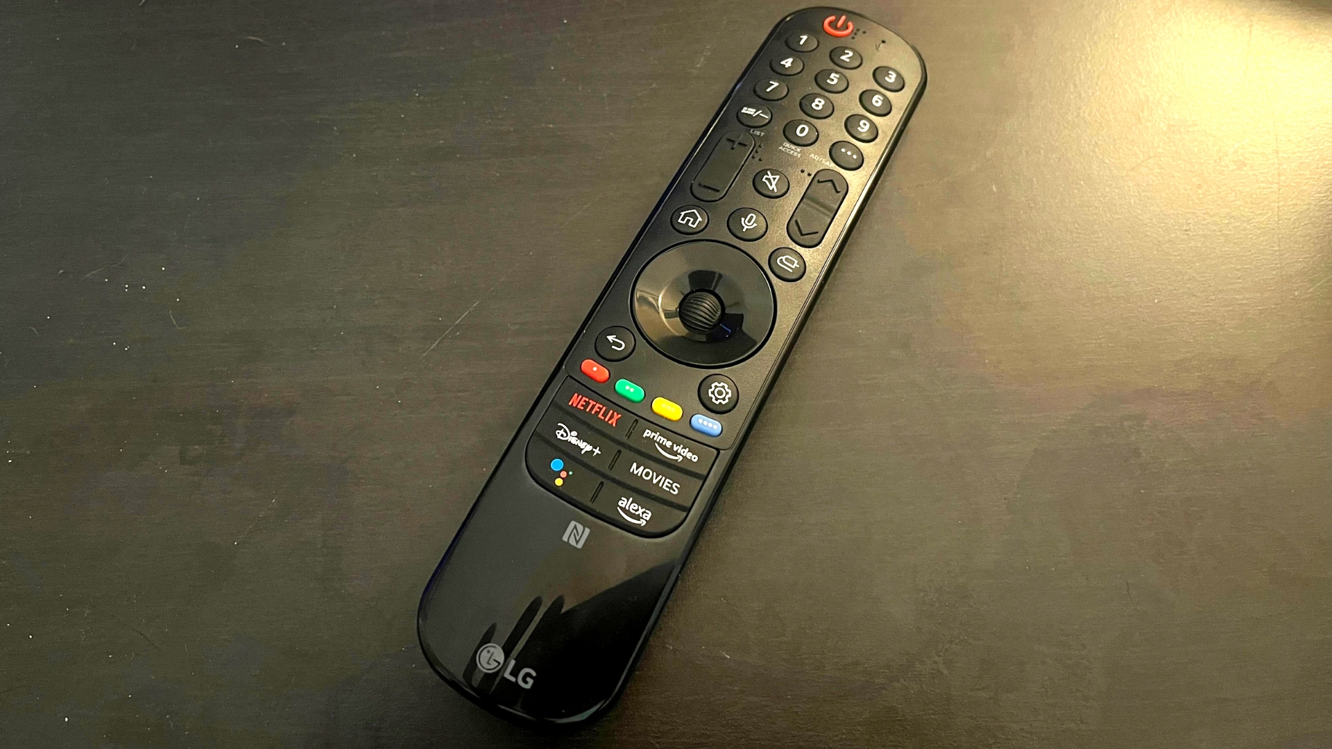 The LG CS' magic remote sitting on a black table