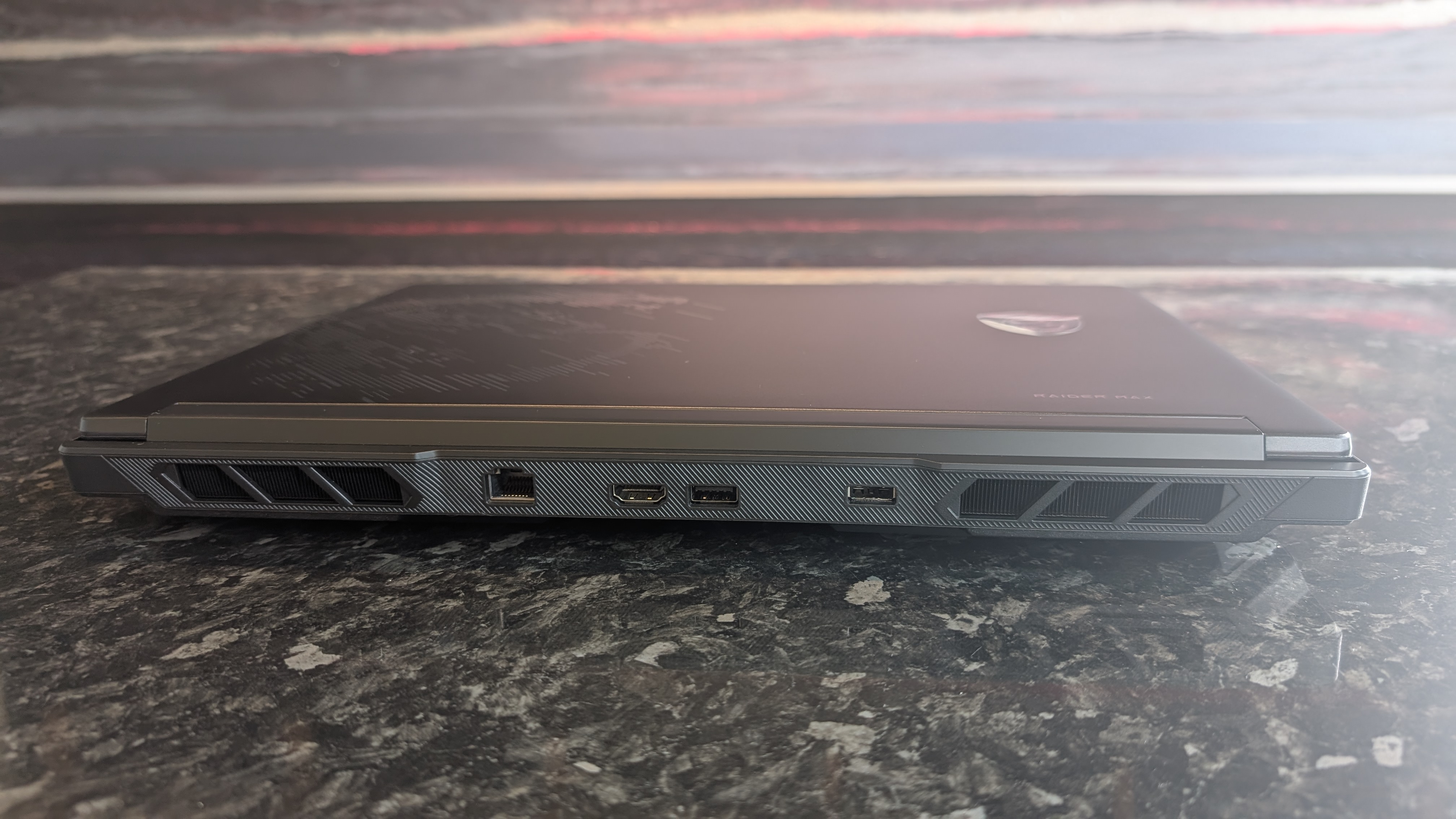 The MSI Raider 16 Max HX gaming laptop pictured on a black marble worktop.