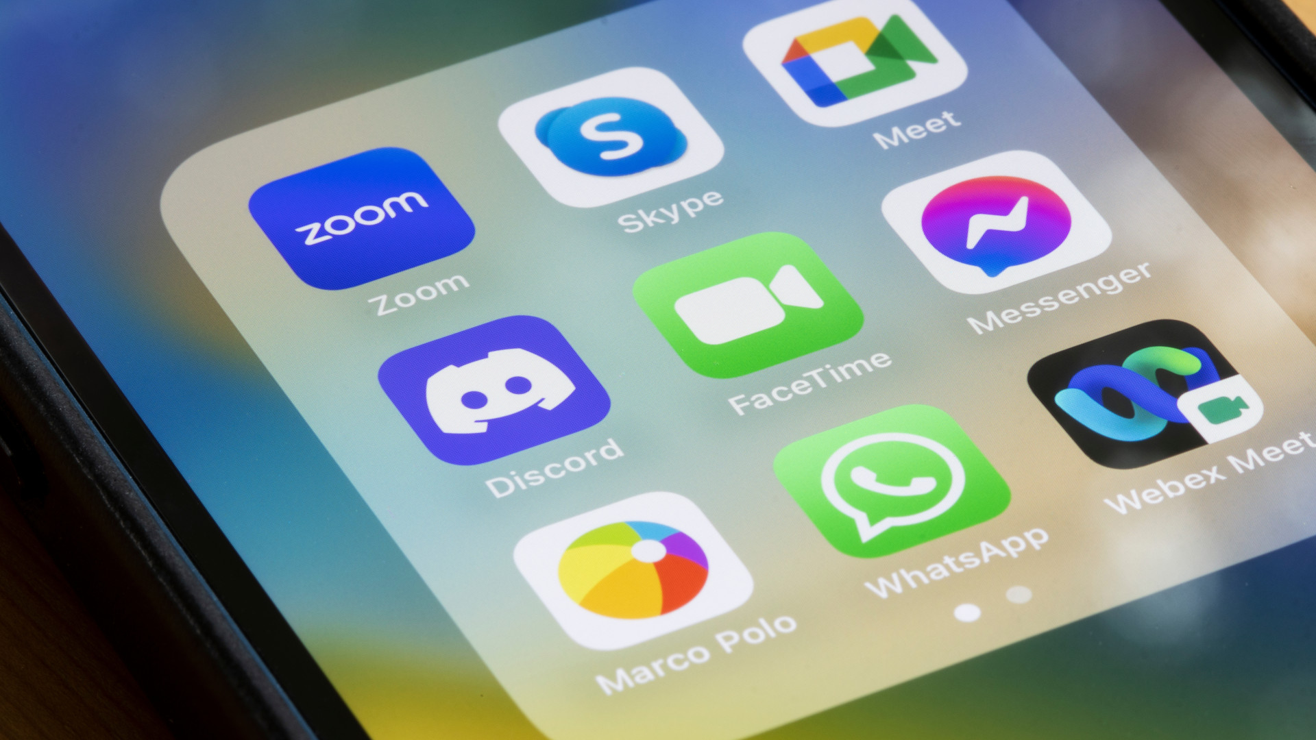 Assorted video chat apps are seen on an iPhone, including Zoom, Skype, Google Meet, Discord, FaceTime, Messenger, Marco Polo, WhatsApp, and Cisco Webex Meetings.