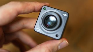 A hand holding the DJI Action 2 action camera