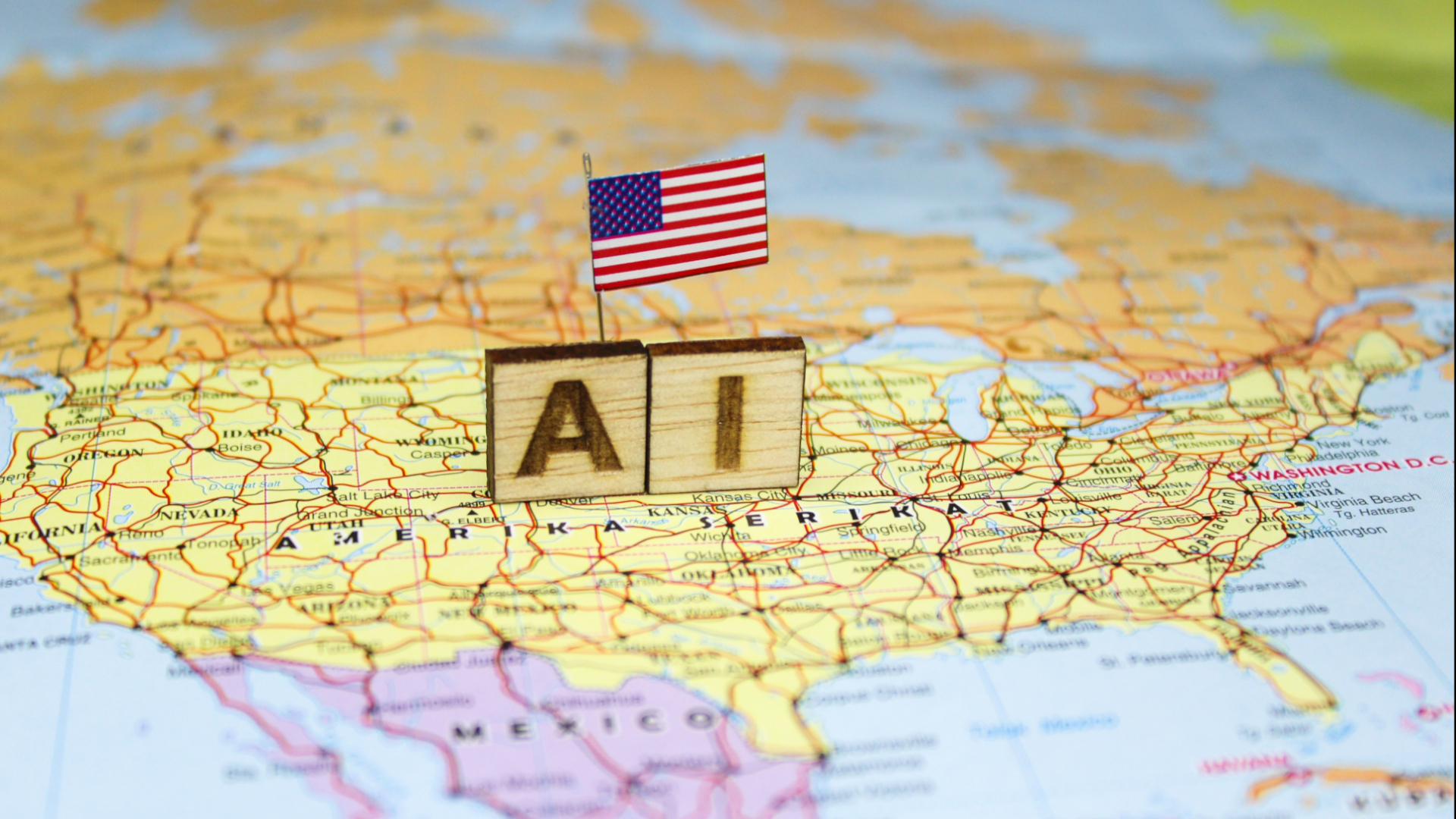 The word &ldquo;AI&rdquo; is composed of wooden blocks on a map of the United States with the US flag, reflecting the advancement of artificial intelligence in the American economic and technological landscape