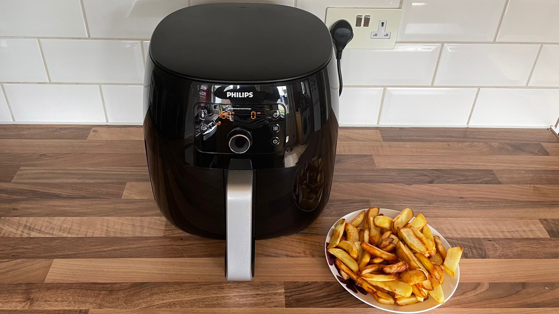 Philips Airfryer XXL HD9650/99 next to a plate of chips that were cooked in the air fryer