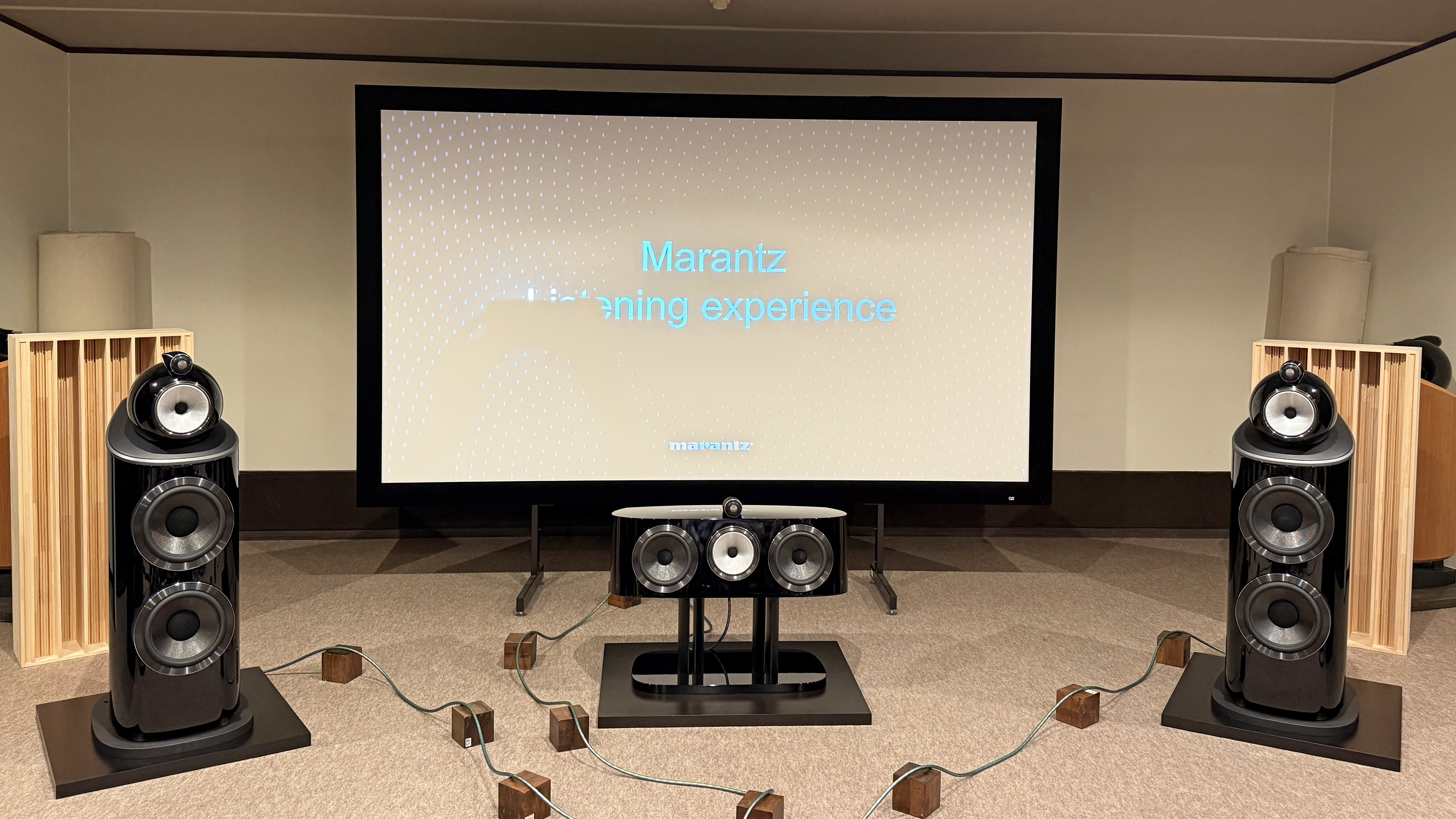 The interior of a home theater listening room with Bowers &amp; Wilkins 801 D4 speakers and a center channel positioned in front of a projector screen