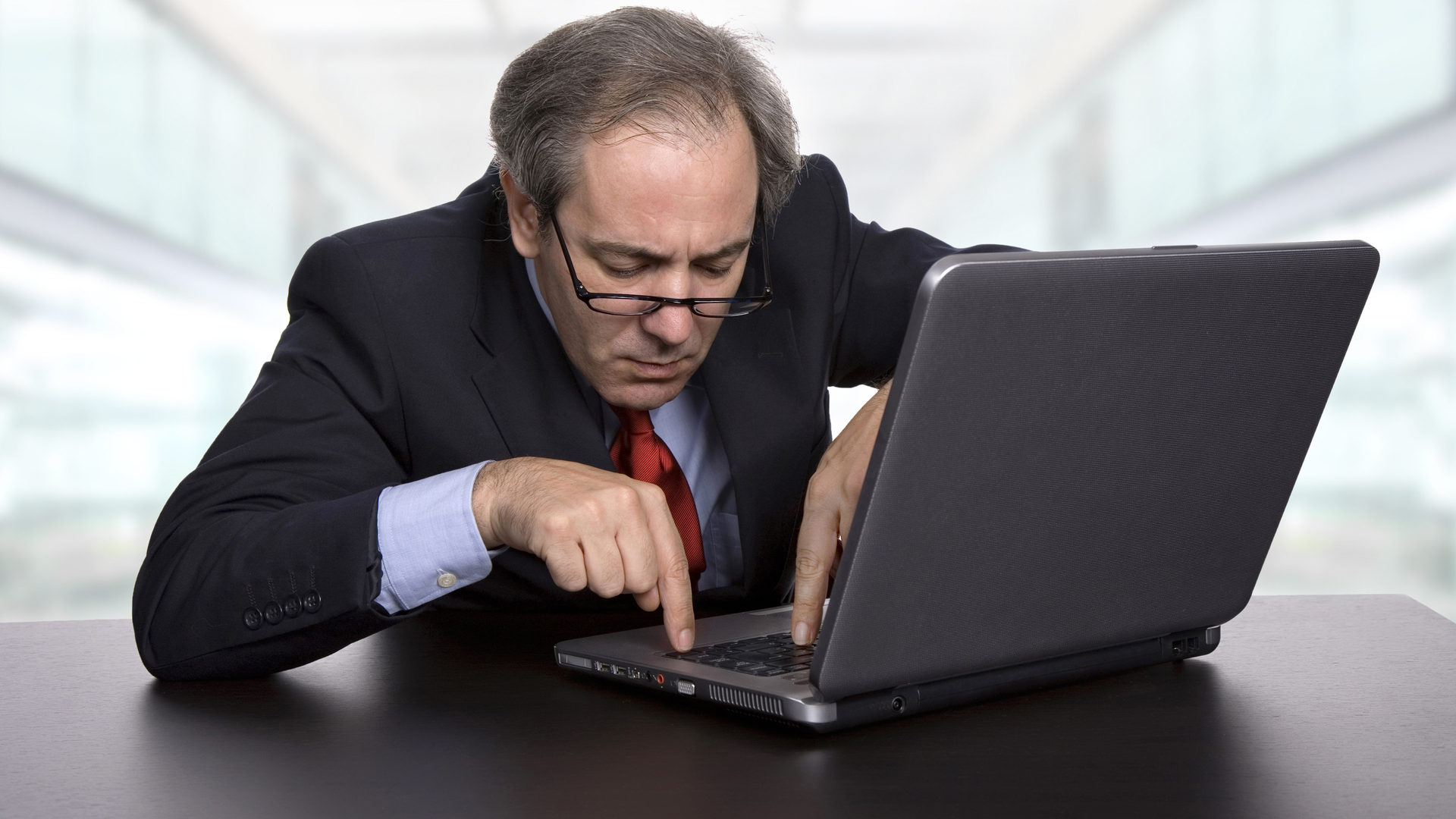 COnfused  businessman working with his laptop, at the office