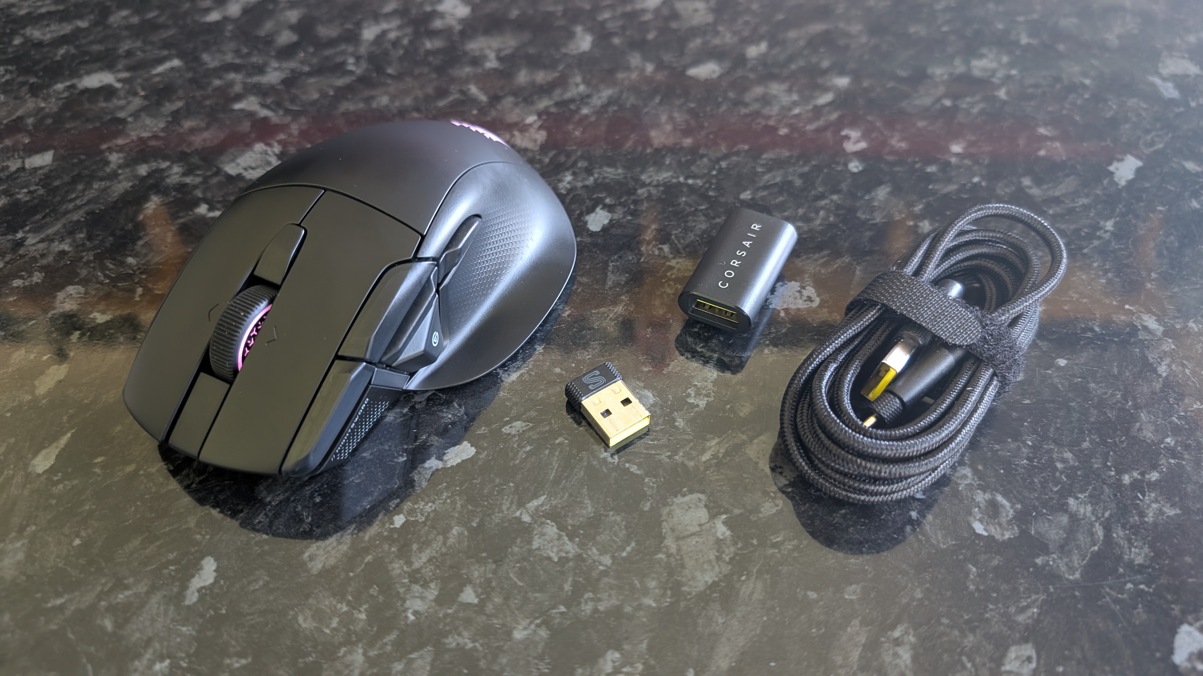 The Corsair Nightsword V2 Wireless gaming mouse pictured on a black marble worktop.