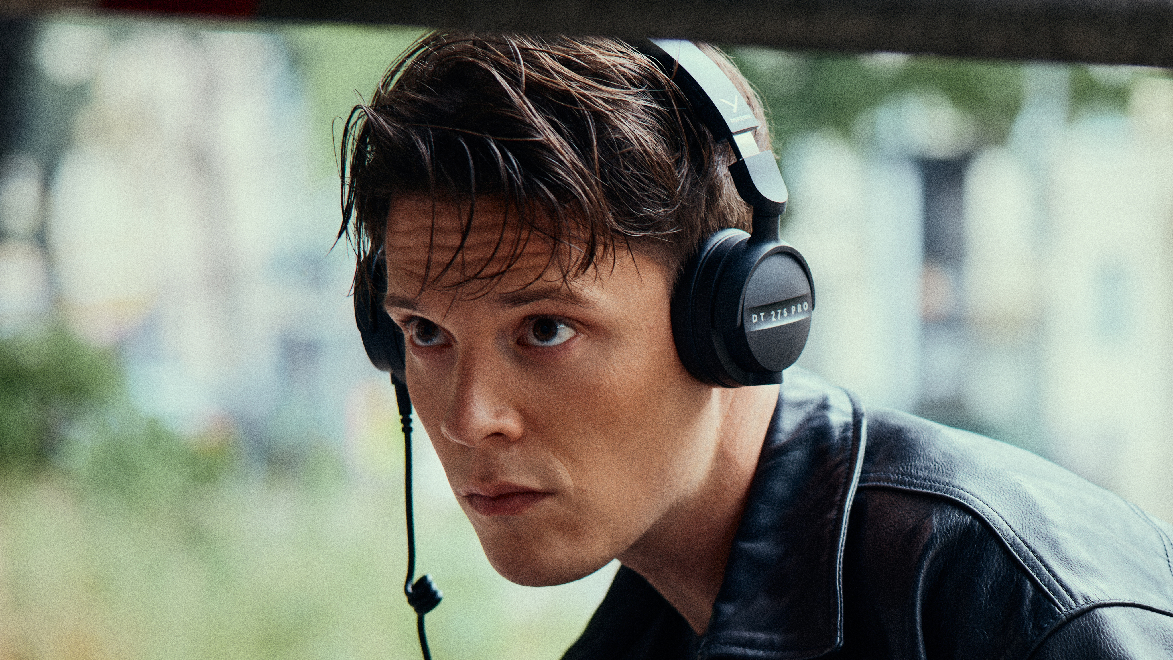 A man wearing Beyerdynamic DT 275 Pro headphones while recording video footage outdoors