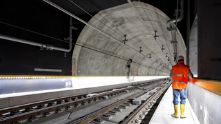 A man using a tablet in a tunnel that's being engineered