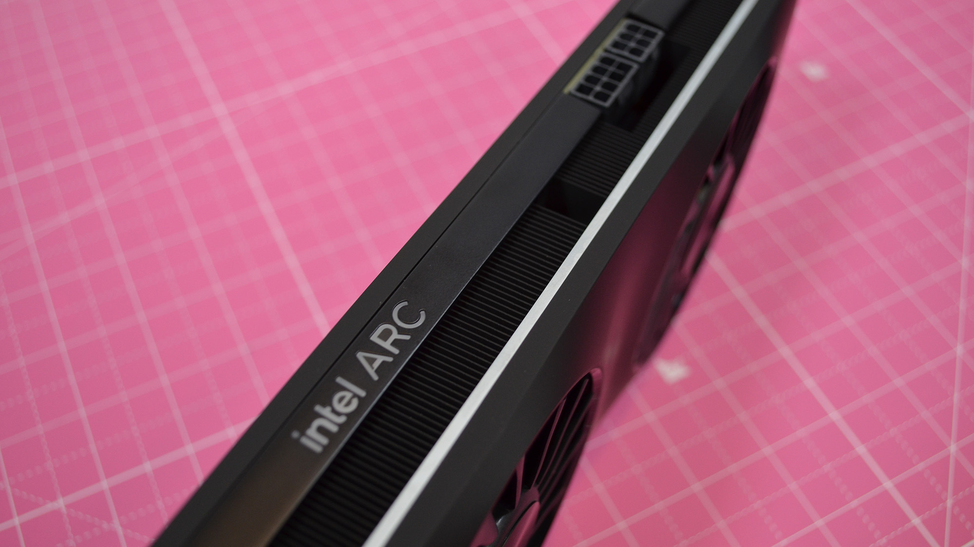 An Intel Arc A770 LE graphics card on a table with a pink desk mat