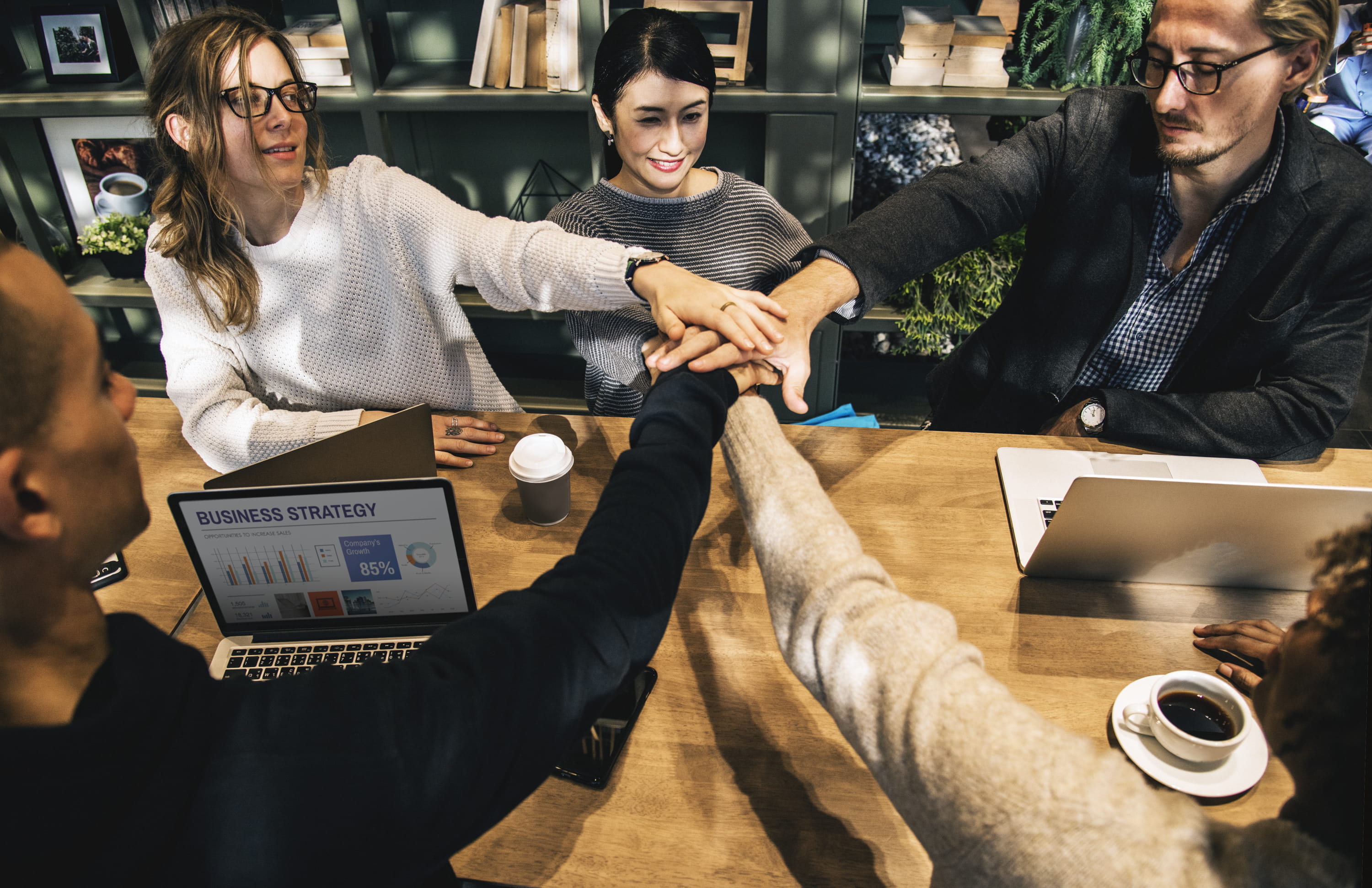 Coworkers stacking hands in a team meeting.