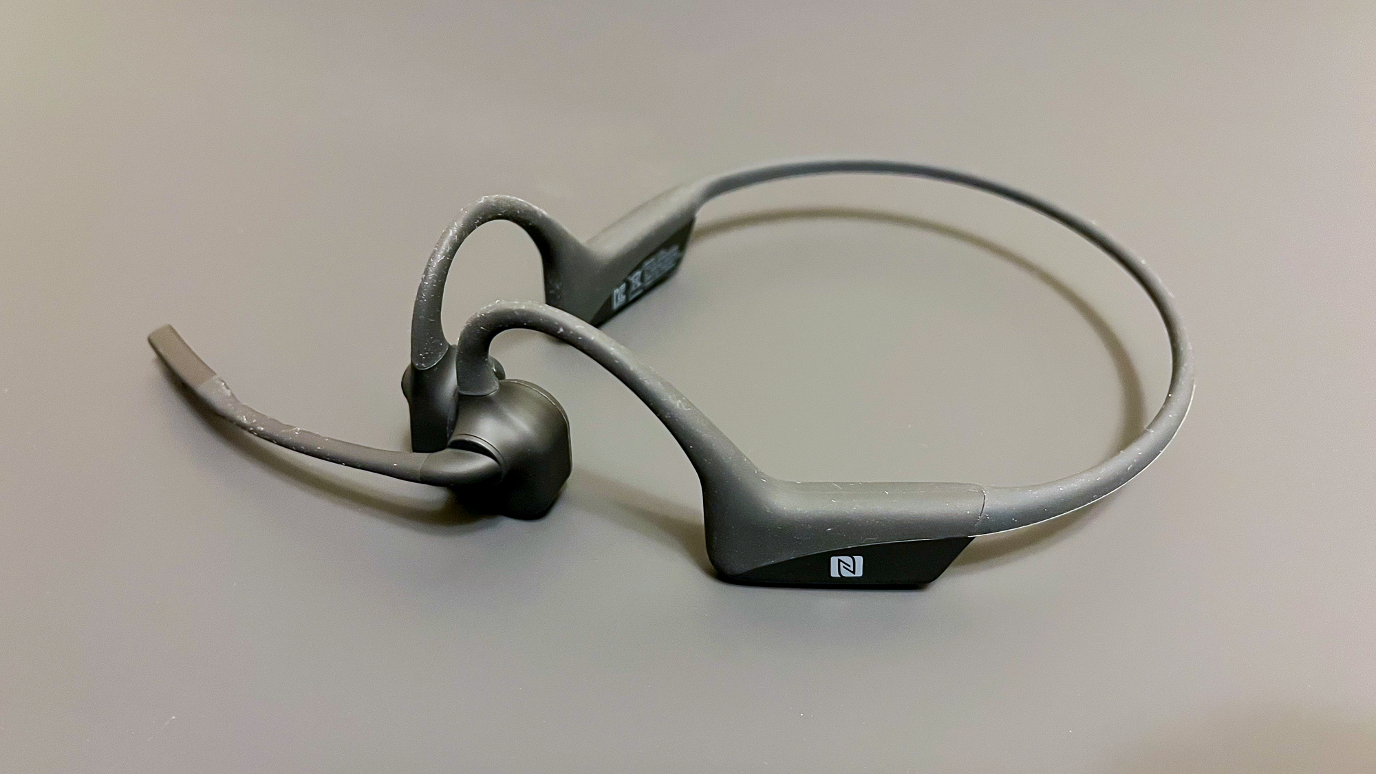 Shokz OpenComm UC on a gray surface