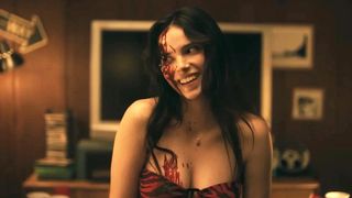A bloodied Nikki with an unsettling smile on her face in Obsession