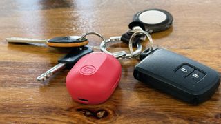 JLab JBuds Mini ANC earbuds attached to a set of keys, showing the case is smaller than a car key fob