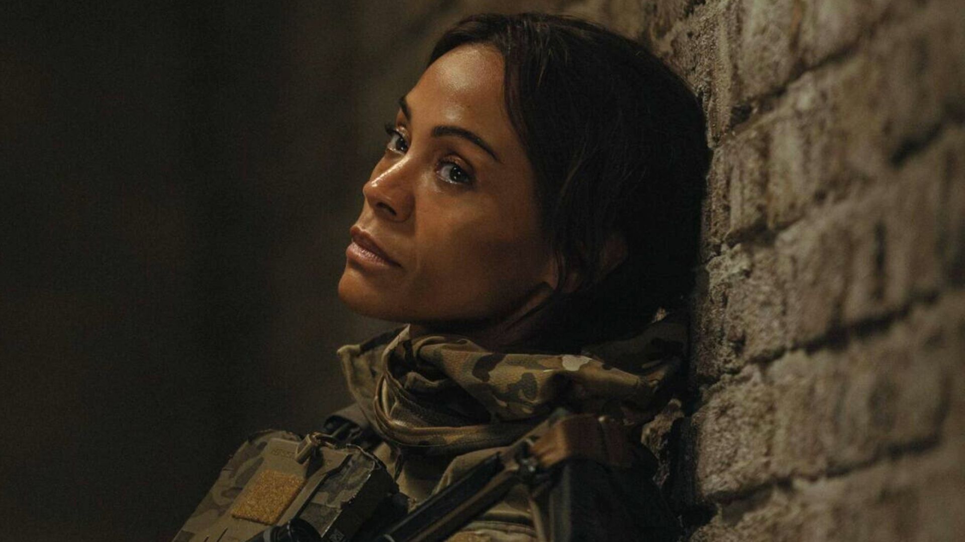 Zoe Saldana sits slumped against the wall