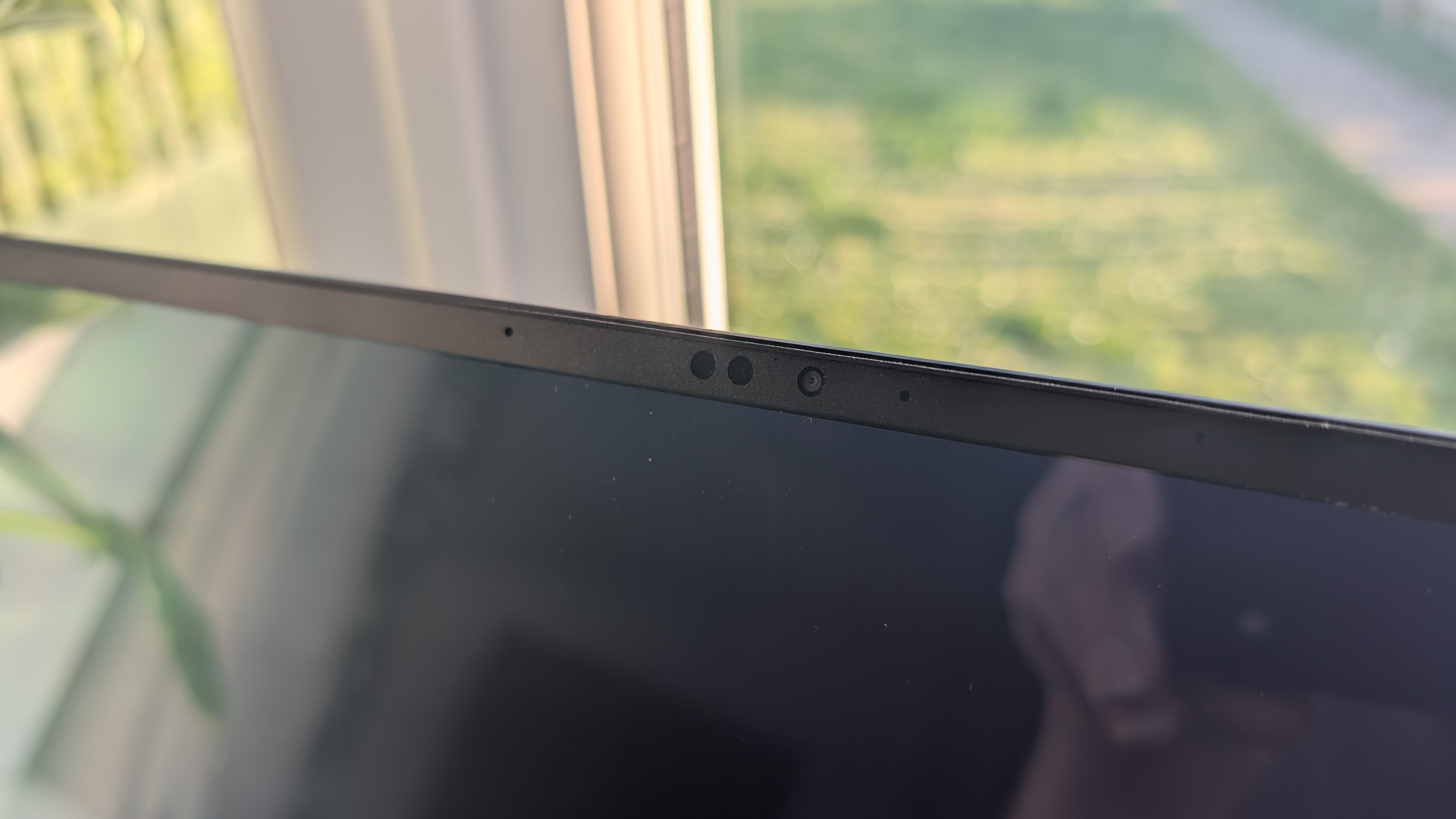 The Razer Blade 16 photographed for TechRadar on a white surface with plants in the background.