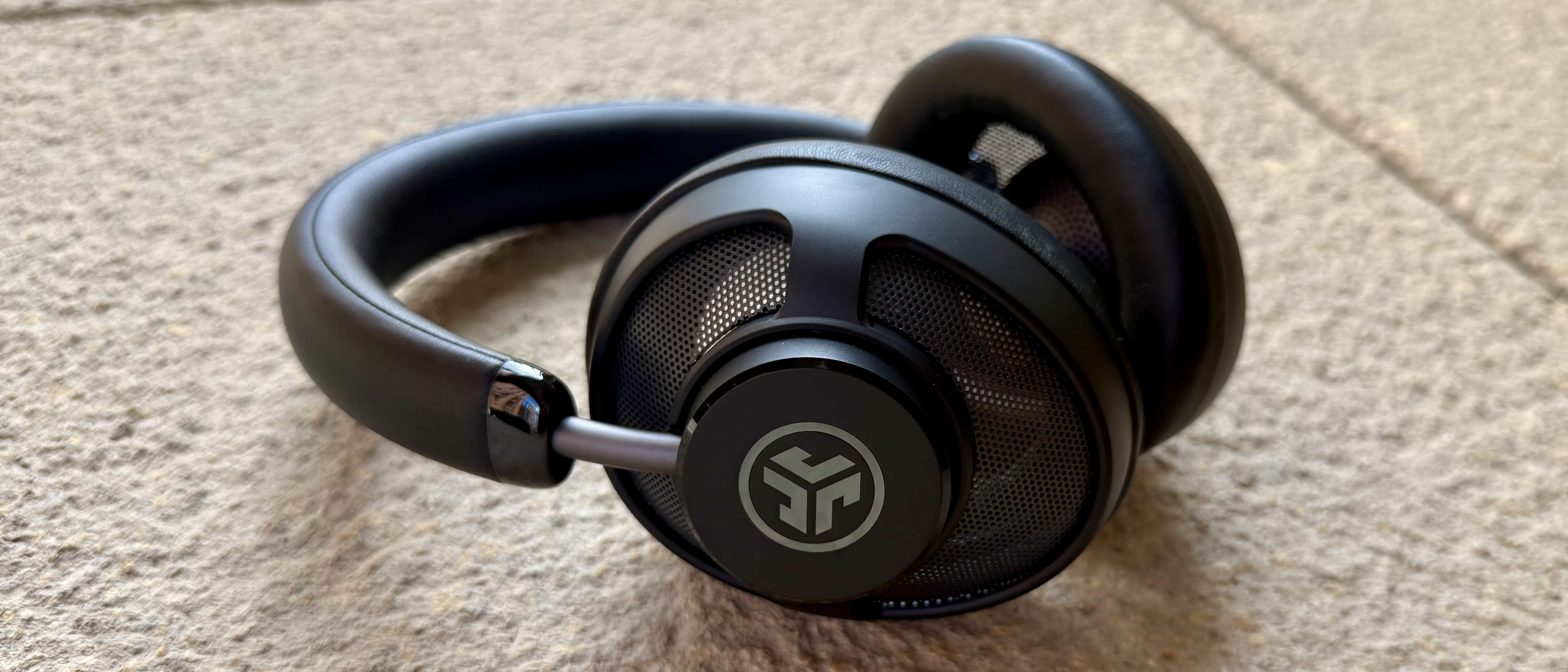 The jlab jbuds open wireless headphones pictured on a stone surface