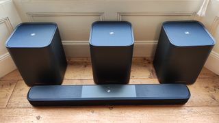 Sennheiser Ambeo Soundbar Plus with subwoofers on a wooden floor