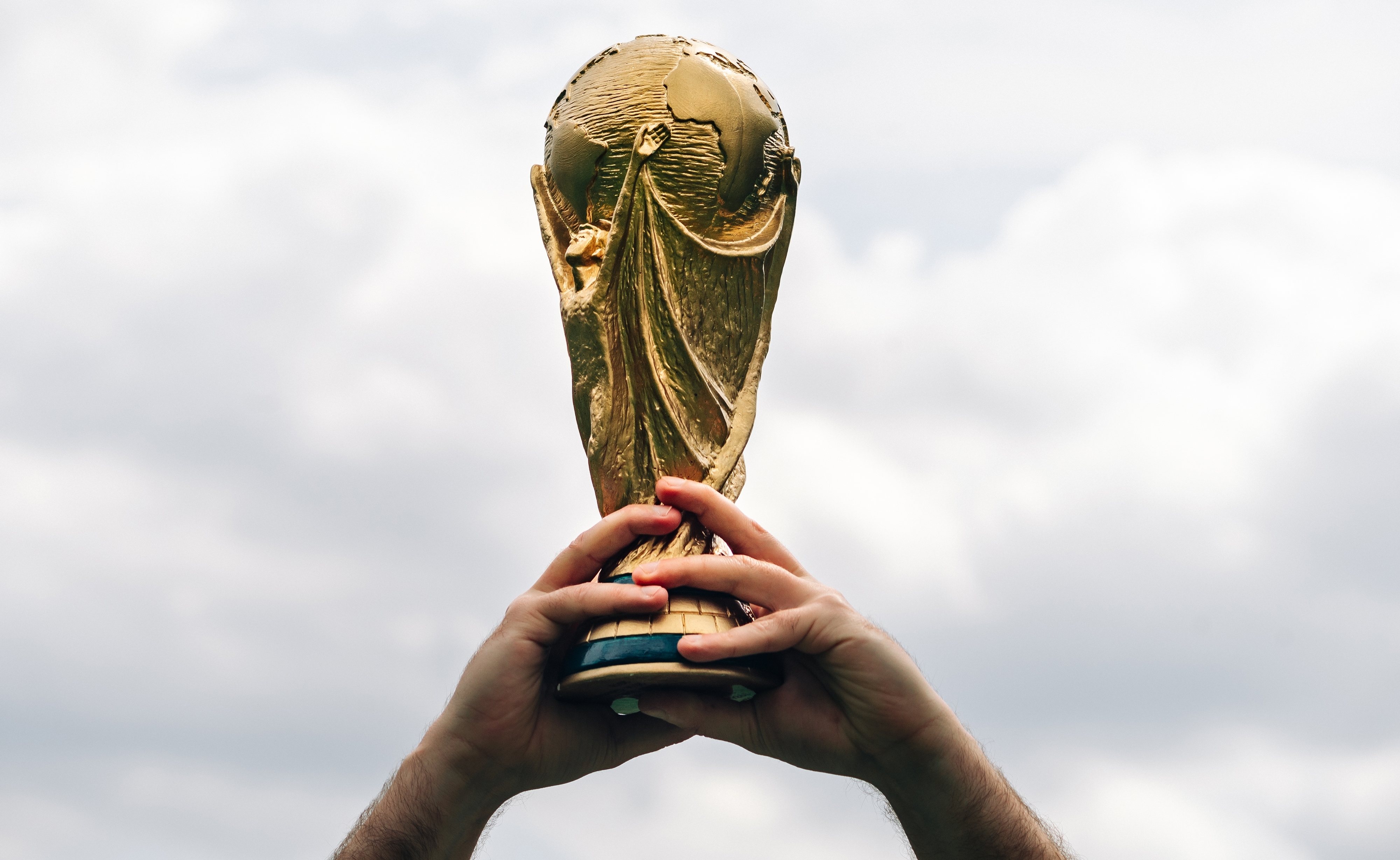 A man holds the FIFA World Cup in his hands.