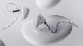 Activo Scoop IEMs on a white pebble