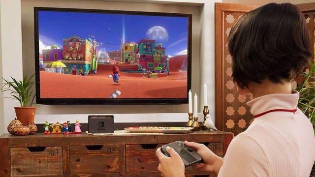 Woman playing Super Mario Odyssey on a Nintendo Switch in TV mode
