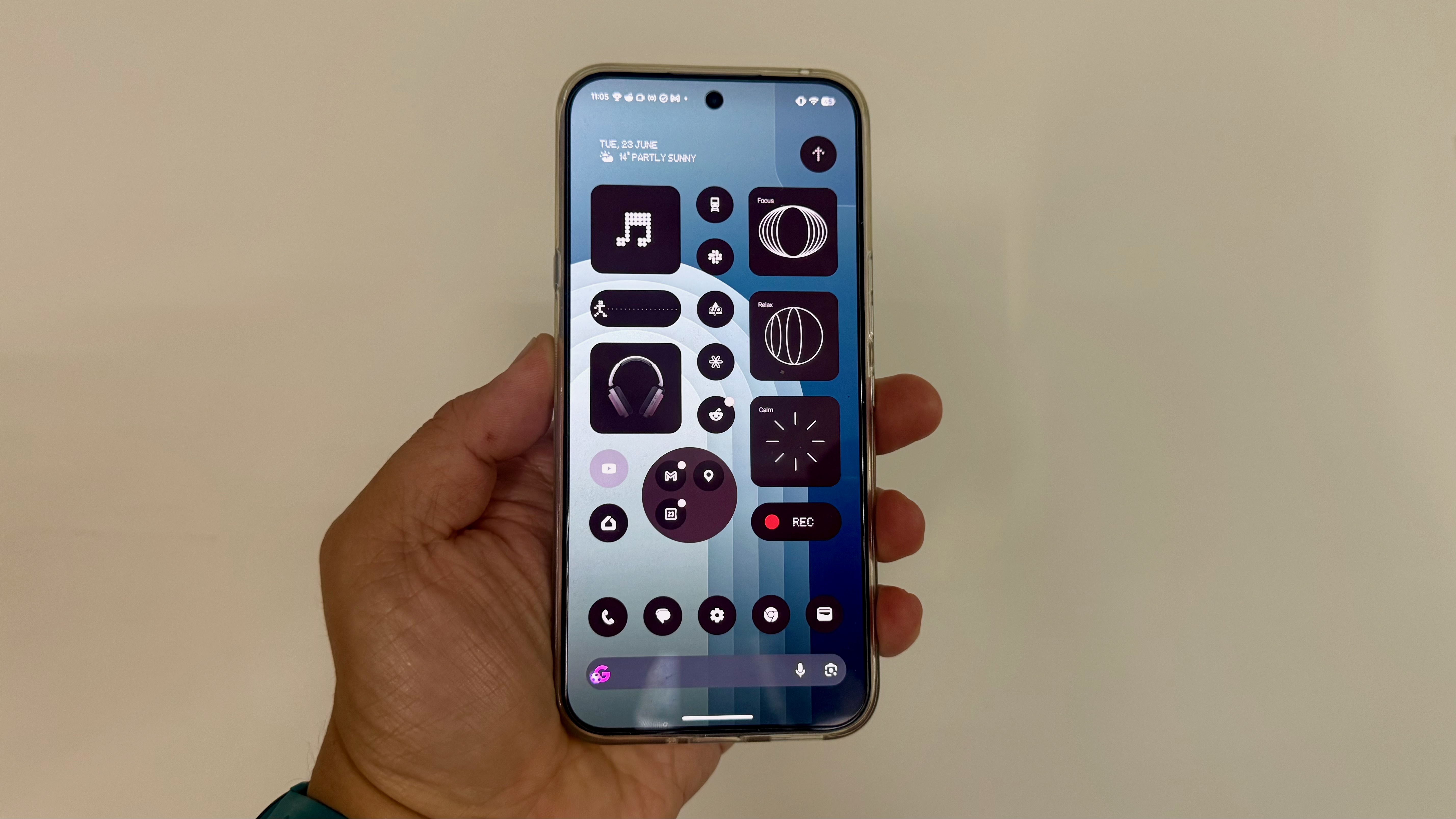 A Nothing Phone 4a Pro in a hand showing the homescreen filled to the brim with widgets and icons