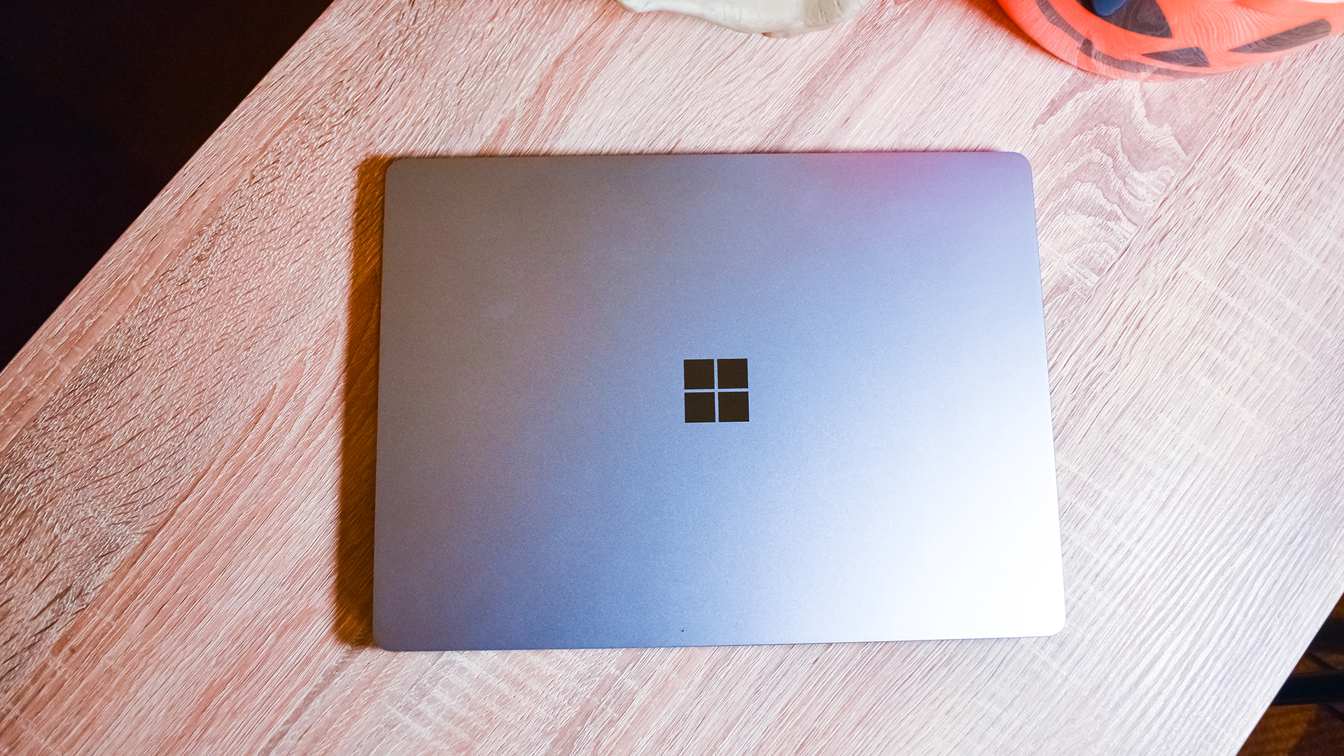 A closed Surface Laptop Go sitting on a wooden desk
