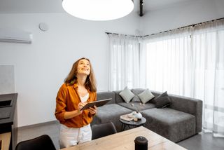 Woman controlling a smart light from an app on her tablet