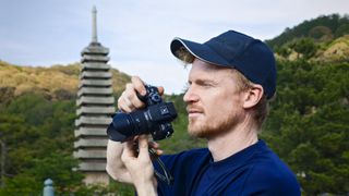 Man holding the Panasonic Lumix G1 mirrorless camera's viewfinder up to his eye