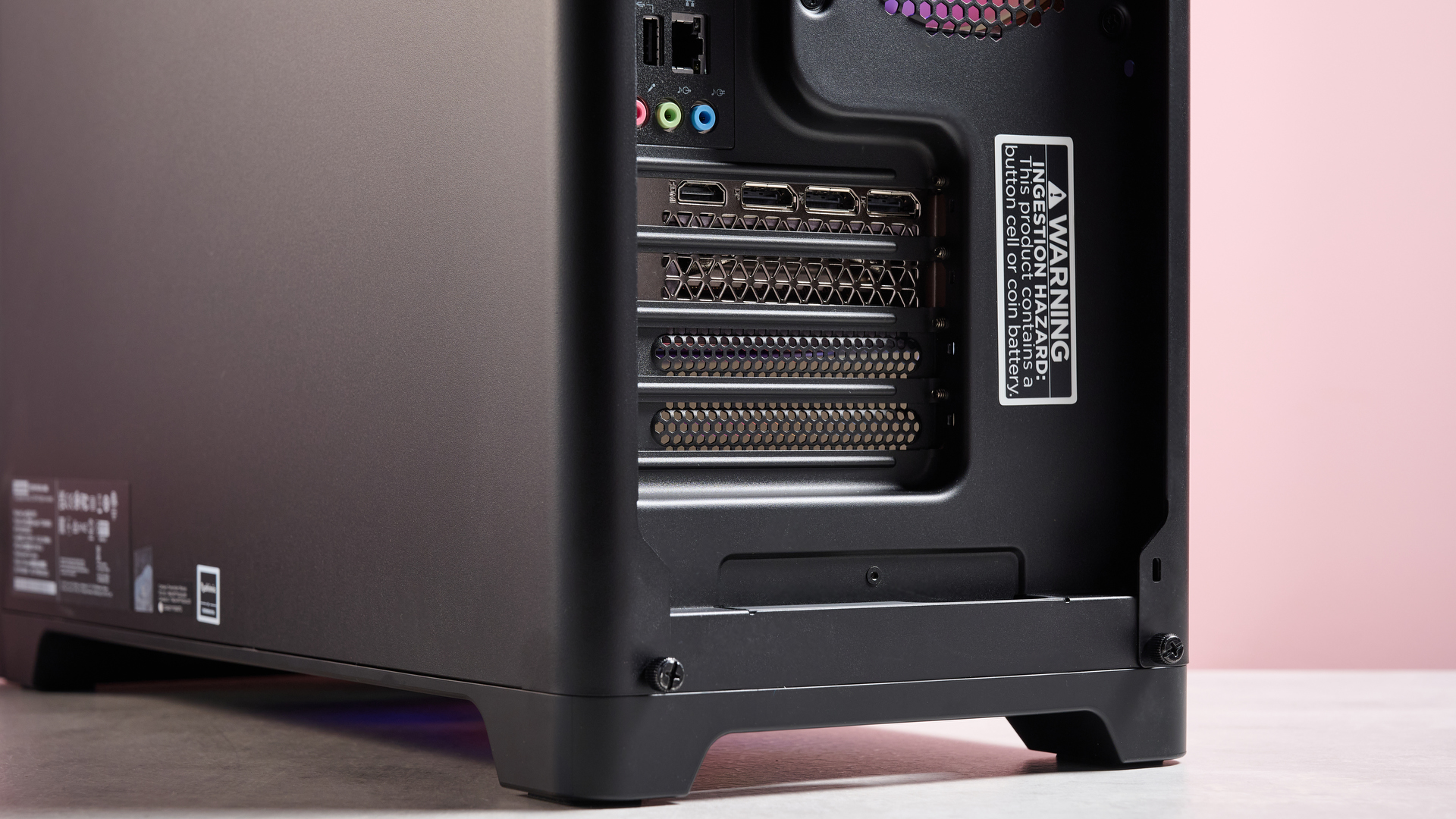 Close-up of bottom-rear portion of the Lenovo Legion Tower 5, with pink wall in background
