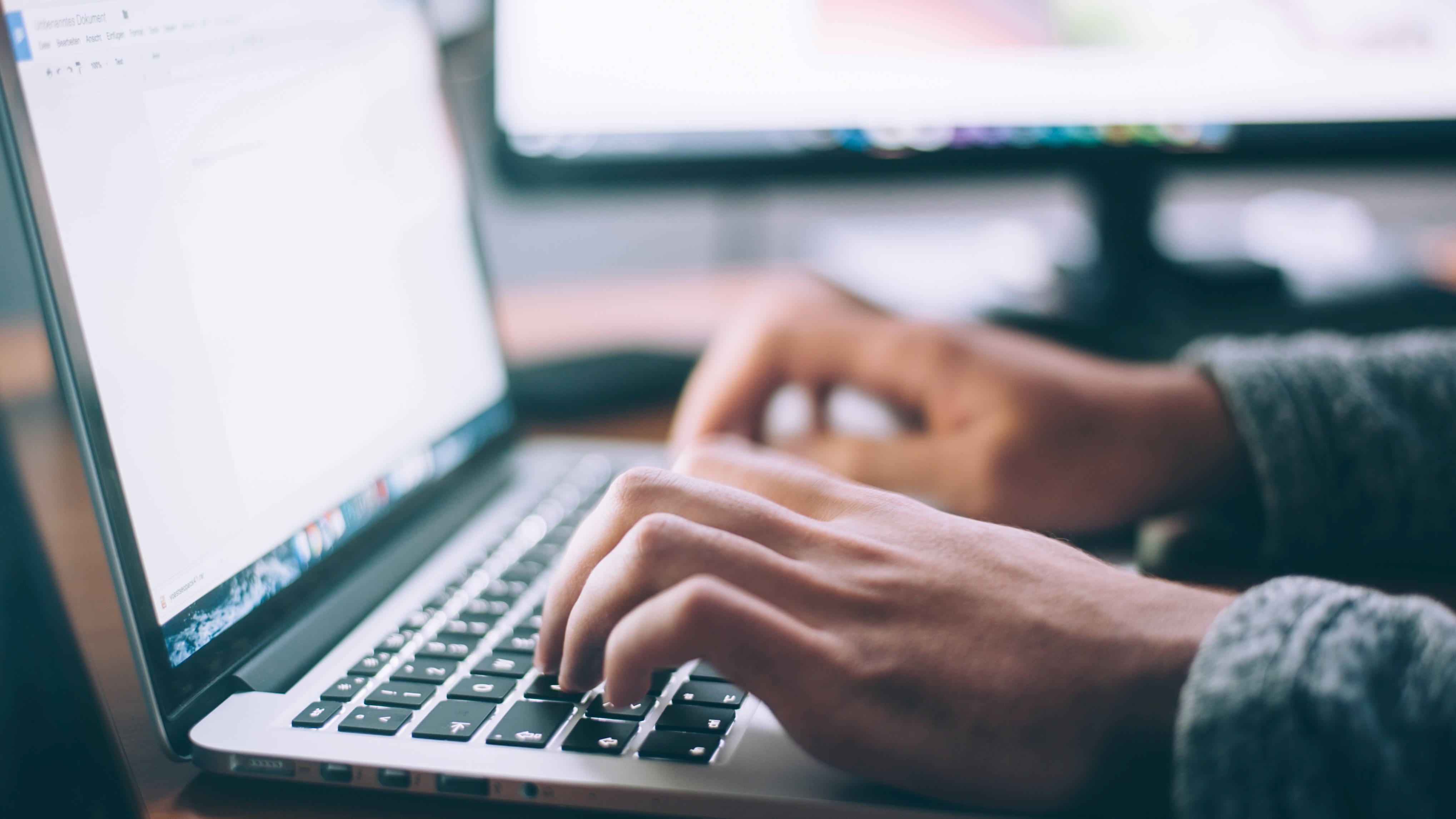 Person Writing on a Laptop