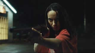 A close-up of Patricia pointing a shotgun at someone off-camera in Widow's Bay episode 8