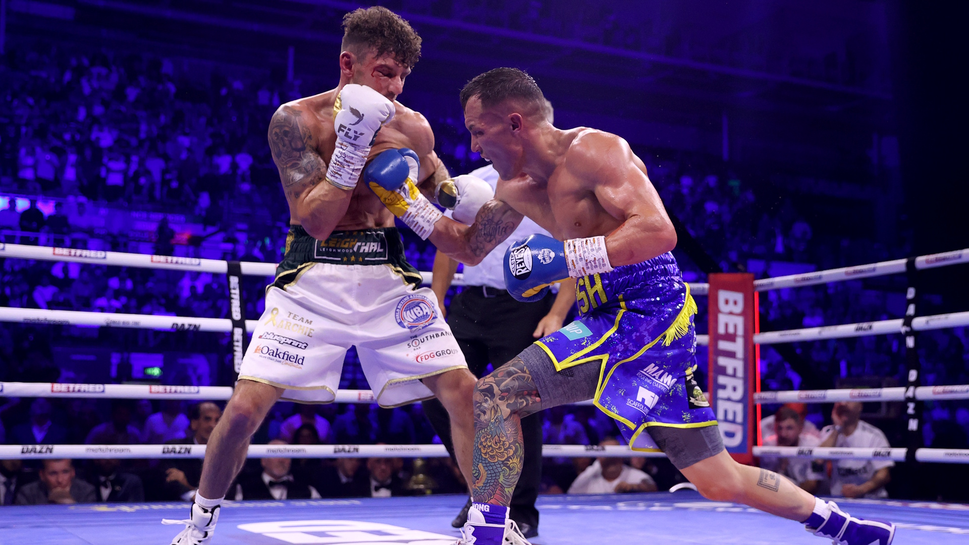 Josh Warrington punches Leigh Wood during the WBA World Featherweight Title fight between Leigh Wood and Josh Warrington.