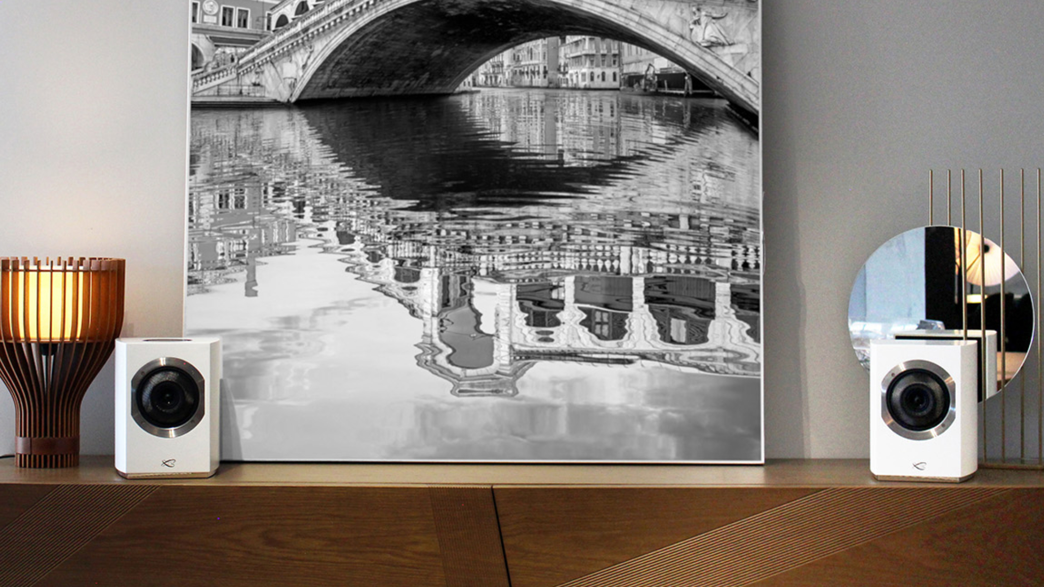 Cabasse Rialto speakers on a mantlepiece, with a picture of the Venice Rialto bridge in the background