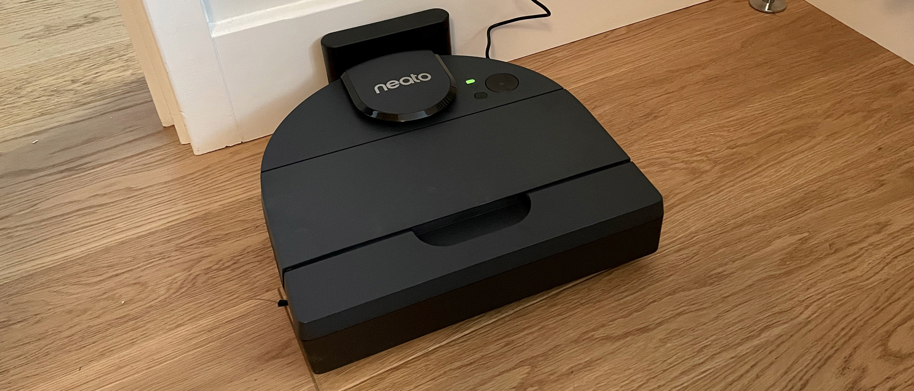 The Neato D8 on its dock on hard wood floor