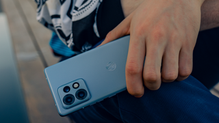 The Motorola Edge 40 Pro held by a model in blue.