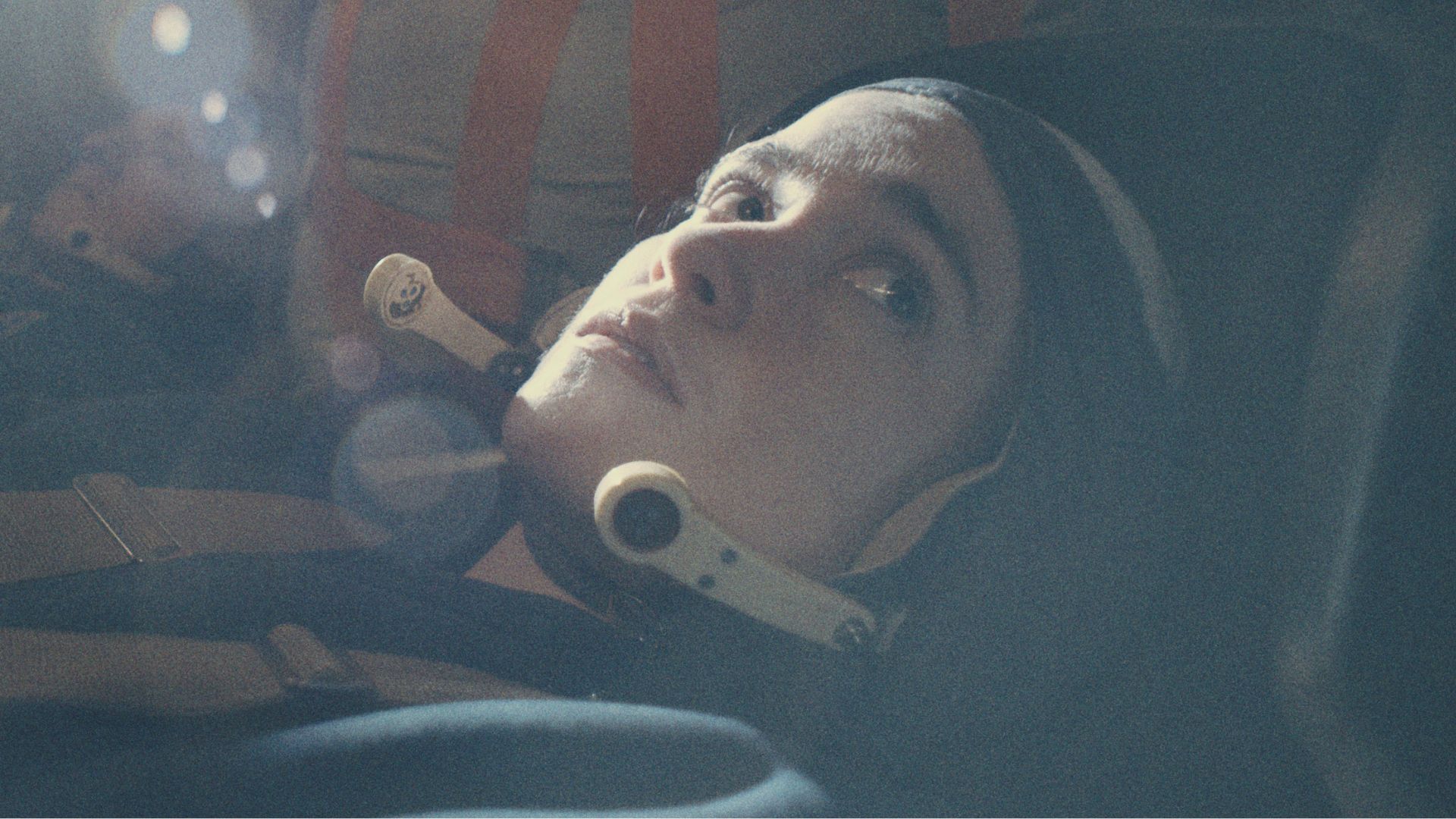 Close up head shot of a female astronaut inside a space craft