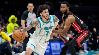 LaMelo Ball #1 of the Charlotte Hornets drives to the basket while guarded by Andrew Wiggins #22 of the Miami Heat.