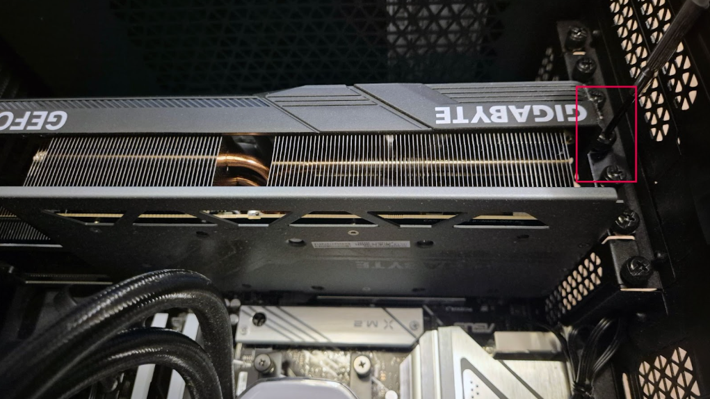 A graphics card inside a PC case with its securing screw highlighted